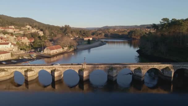 空中無人機は 昼間にスペインのガリツィア ポンテベドラのアーケード街の横に位置するVerdugo川のSampaioと呼ばれる中世の橋の上で撮影しました — ストック動画