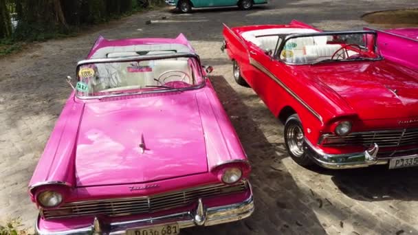 赤とピンク1957フォードフェアレーンコンバーチブル車キューバのハバナの道で駐車し 表示します パンニング — ストック動画