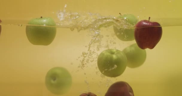 Ένα Μάτσο Κόκκινα Και Πράσινα Μήλα Πεταμένα Στο Νερό — Αρχείο Βίντεο