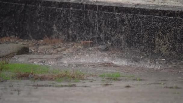 大雨倾盆时 屋外渗出的雨水落在屋外的泥土上 — 图库视频影像