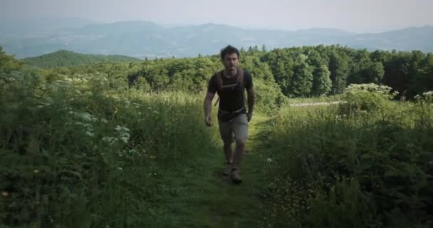 Gimbal Totale Kamerafahrt Eines Wanderers Der Zwischen Gras Und Blumen — Stockvideo