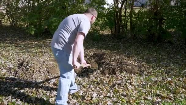 用铲子追踪白人男性 在后院挖一个洞 慢动作射击 — 图库视频影像