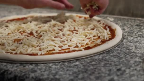 Las Manos Espolvorear Queso Mozzarella Rallado Sobre Salsa Roja Pizza — Vídeos de Stock