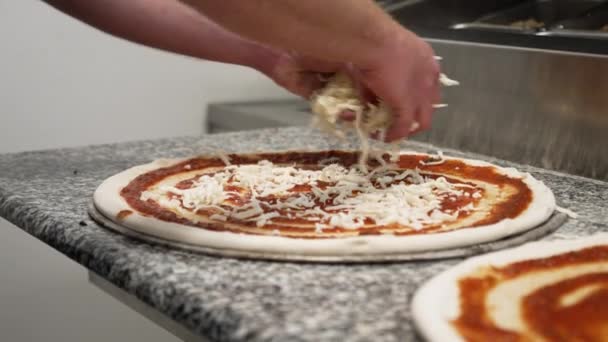 Шеф Повар Посыпает Горсть Измельченного Сыра Моцарелла Поверх Теста Пиццы — стоковое видео