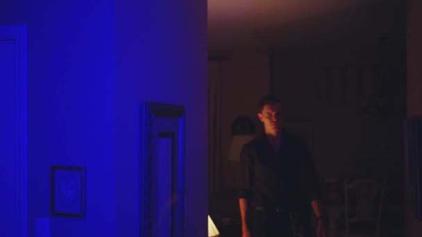 好奇的白种人带着夜晚反射的警灯在屋里散步 — 图库视频影像