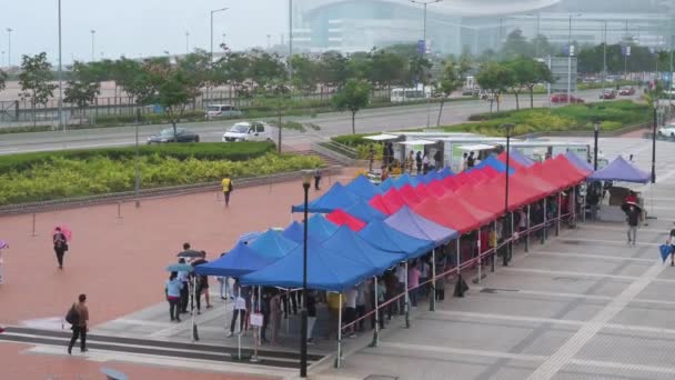 市民排队接受社区检测中心卡车提供的大规模的验尸报告 Covid 以应付该病毒及该传染病在香港的蔓延 — 图库视频影像