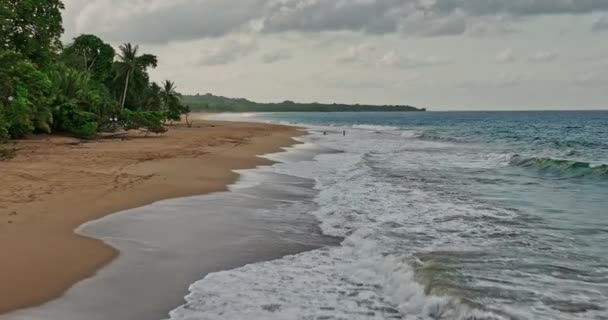 Bocas Del Toro Panama Aerial V1电影中的低空低空盘旋沿着荒凉的海滩 海浪冲撞 海滩游人在海水中放松 与Mavic Cine一起射击 — 图库视频影像