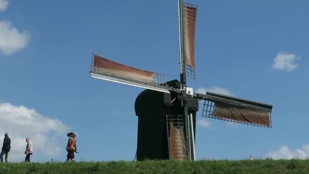 荷兰80年的战争重演 布尔坦吉村的一位居民正坐在堤坝上从风车旁经过 — 图库视频影像