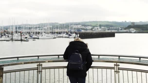 プリマス ハウスから港を見下ろす展望台の女性観光客 ミディアムショットバックビュー — ストック動画
