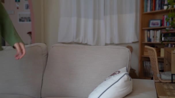 アパートのリビングルームに座って熱い飲み物を楽しむ女性 — ストック動画