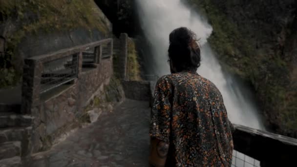 バノス エクアドルのリオ ヴェルデにある悪魔の釜の滝の展望バルコニーで歩く人のバックビュー — ストック動画