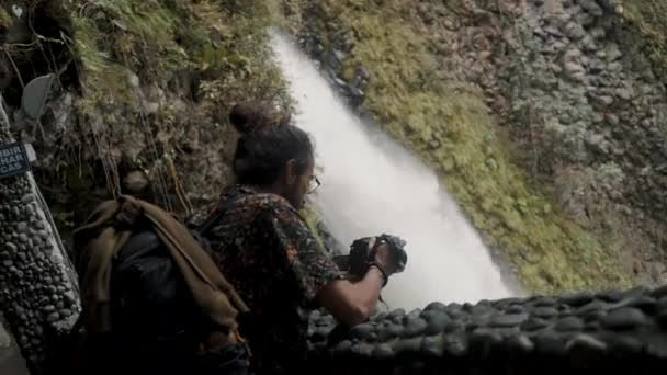 Mężczyzna Podróżujący Oglądający Swoją Kamerę Pobliżu Wodospadu Pailon Del Diablo — Wideo stockowe