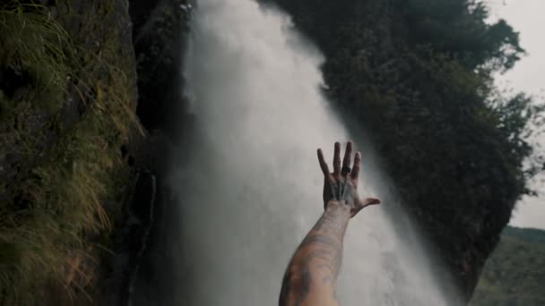 エクアドルの悪魔の釜の滝への空気中の男性の手 クローズアップ — ストック動画