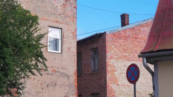 晴れた日に古い赤レンガ造りの家の窓 白い塗装木枠 古い住宅外観 ダウンタウンLiepaja ラトビア 遠くの広角ショット — ストック動画