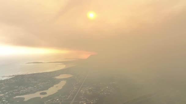 南アフリカのケープタウン近くのベティ湾での野火の間 濃いオレンジ色の煙は太陽を見えなくします ドローンビュー — ストック動画