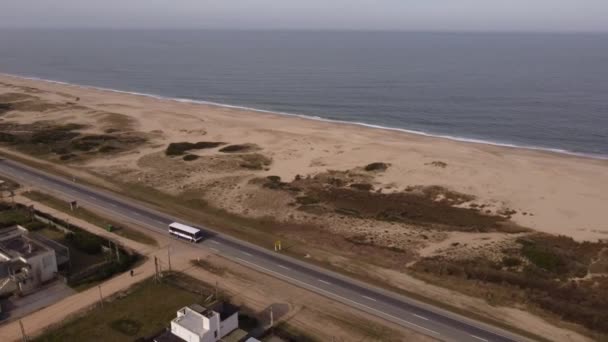 沿着乌拉圭马尔多纳多地区沿海海洋公路行驶的白色公共汽车 空中无人驾驶飞机 — 图库视频影像