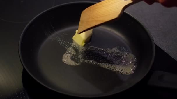 黄油在热腾腾的油锅上融化 人们用意粉涂黄油 — 图库视频影像