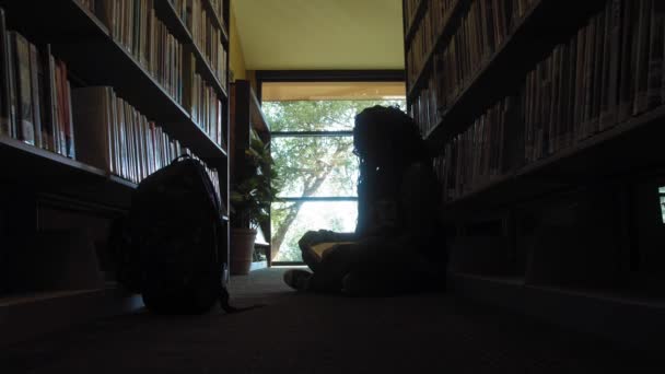 Kaunis Nuori Musta Nainen Lukee Lattialla Kirjastossa Dolly — kuvapankkivideo