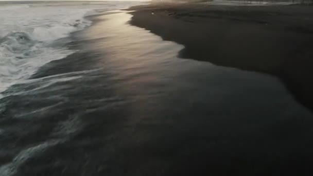 Černá Písečná Pláž Pěnivými Vlnami Stříkající Pobřeží Při Západu Slunce — Stock video