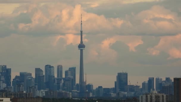 日の出や日没の間に白い雲が浮かんで高層ビルやCnタワーと雄大なトロント市のスカイライン — ストック動画