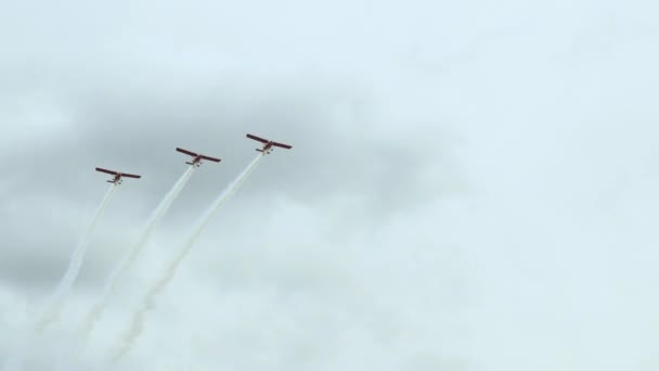 在拉脱维亚丽帕雅的波罗的海航展上 三架在观众席前进行动态机动飞行的红色航空飞行器在白烟小径上飞行 — 图库视频影像