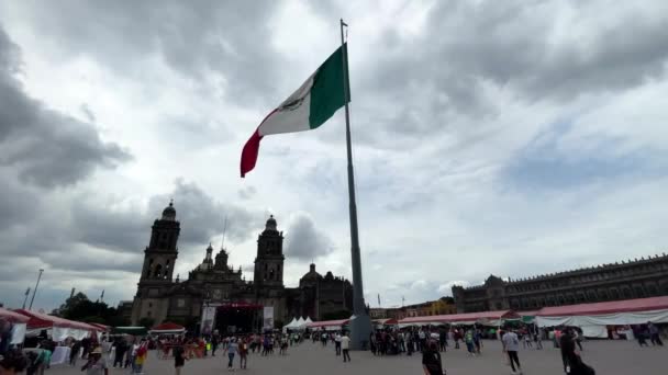 大聖堂前のメキシコシティのゾカロに手を振っているメキシコの旗のスローモーションショット — ストック動画