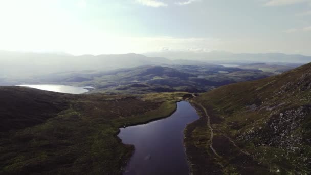 草に覆われた山々の中に広がるラフとアイルランド高地の美しい空中 草原の山々や谷を明らかに後ろの距離です 夏の夕方の空飛ぶ鳥 — ストック動画