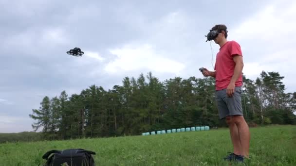 Férfi Szemüveggel Fejhallgató Mozgásszabályozó Előtt Áll Fpv Drone Meadow — Stock videók
