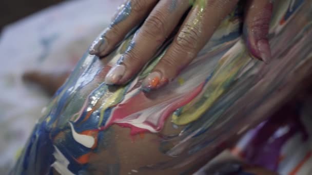 一个女人的手抬起腿 在她的身体上混合着鲜亮的彩色颜料 — 图库视频影像