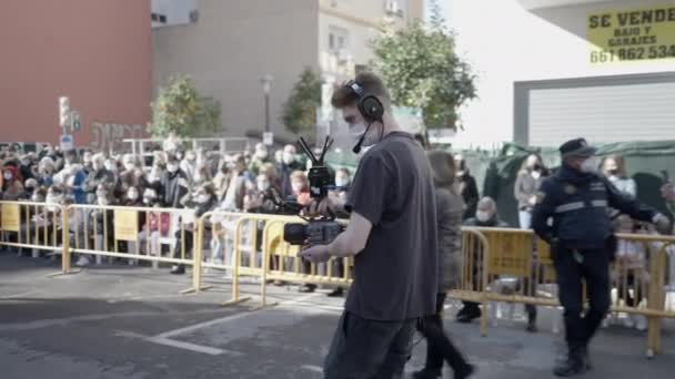 スペインのバレンシアでサンアントニ祭りの間に街で内蔵マイク撮影とプロのカメラとヘッドフォンを持つカメラマン 中程度 — ストック動画