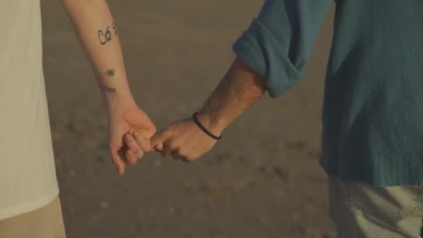 Ευτυχισμένο Ζευγάρι Κρατώντας Χέρια Μαζί Και Περπατώντας Στην Αμμώδη Παραλία — Αρχείο Βίντεο