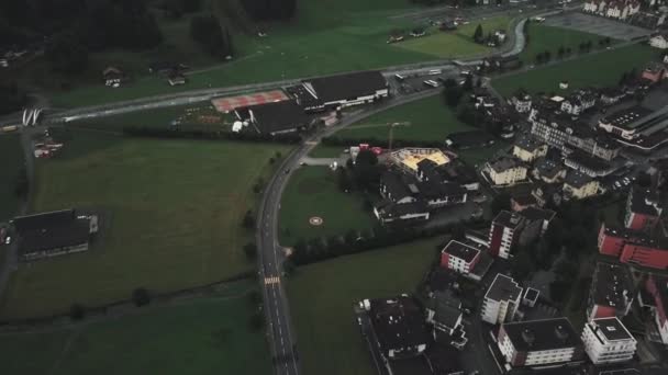 スイスのエンデルベルク上空を飛行し 曇りの日に山脈の建物を見せています — ストック動画