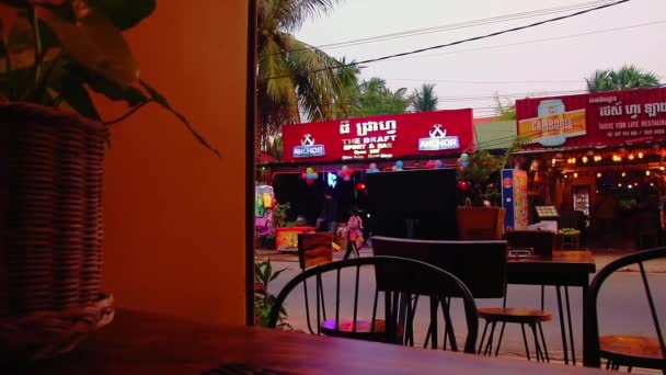 編集部 カンボジアのシェムリアップのダウンタウンの忙しい通りとパブは 別のパブの中から見られる — ストック動画