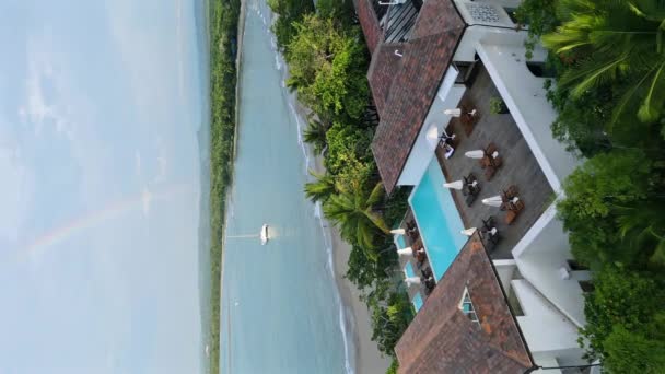 空中垂直拍摄的私人度假胜地与游泳池和帆船在加勒比海的彩虹在天空中 — 图库视频影像