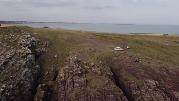 在乌拉圭蓬塔巴莱那半岛悬崖上沿着沿海全景公路行驶的汽车 空中侧向和跟踪 — 图库视频影像