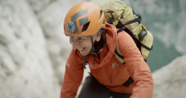 Een Blije Wandelaar Klimmend Een Berg Met Een Oranje Jas — Stockvideo