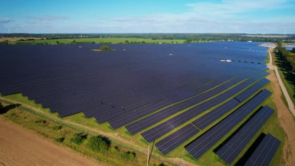 ポーランドの田舎の大規模な太陽電池パネル農場や農村部のパスの空中ビュー パノラマワイドショット — ストック動画