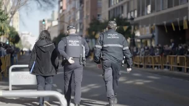 Policjanci Służbie Spacerując Ulicą Utrzymując Porządek Ludźmi Stojącymi Płotem Barykady — Wideo stockowe