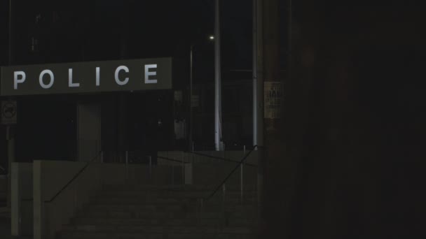 警察在大楼前的静态射击标志 车辆在黑暗中驶过警察分局 — 图库视频影像