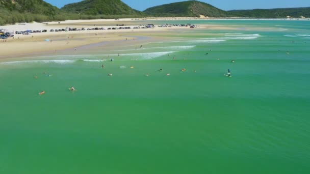 車やキャンプで砂浜の海岸の横にあるターコイズブルーの海でサーファー上の空中4Kドローン オーストラリア — ストック動画