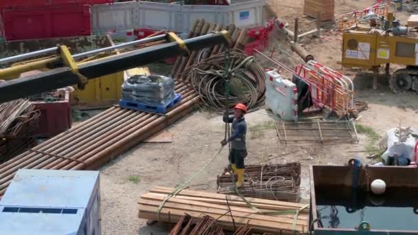 Een Chinese Machinebouwer Helpt Een Kraan Een Stapel Houten Planken — Stockvideo