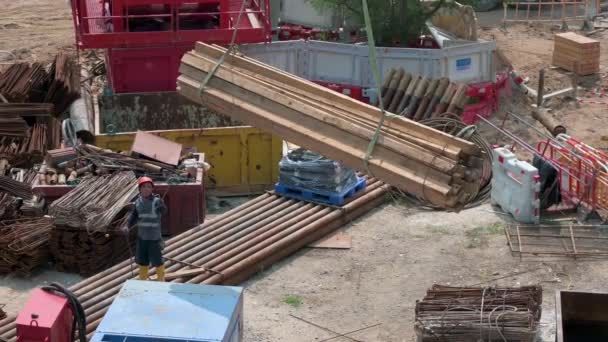 中国の技術者は 香港の建設開発現場プロジェクトで木板を積み上げてクレーンを支援します — ストック動画