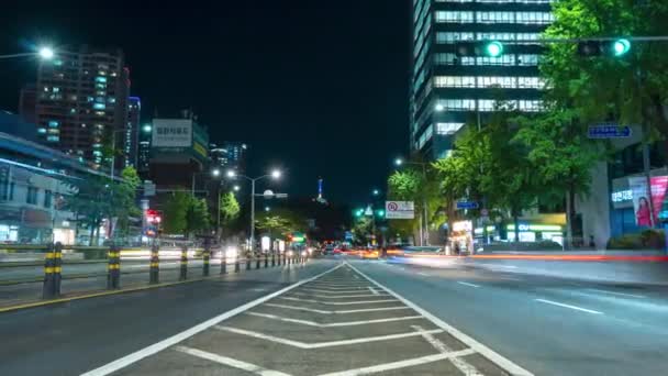 南山タワーまたはNソウルタワーを望むソウル龍山区では 交通シーンのタイムラプスを中心に夜の混雑した街の通り — ストック動画