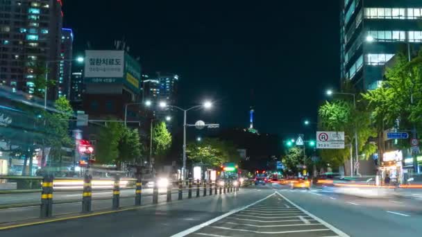 Seoul Namsanタワービュー忙しいソウル市内からの眺め交通信号 ネオンライトトレイルを変化させる高速移動交通時間の経過と夜のダウンタウンストリート パンニングモーション — ストック動画