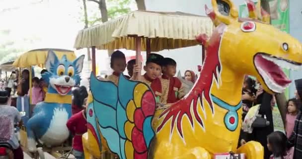 在印度尼西亚西爪哇齐勒邦的艺术与文化狂欢节上 人们乘坐动物复制品火车 — 图库视频影像