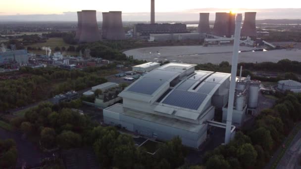 空中からの眺めは 化石燃料発電所の後ろから昇る日の出とスマートソーラー屋上工場の上に下降します — ストック動画