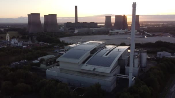化石燃料発電所の空中下降ビューの後ろから日の出と英国のスマートソーラー屋上工場 — ストック動画