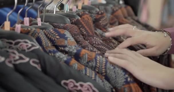 Zbliżenie Niezidentyfikowanego Azjatyckiego Turysty Wybierającego Koszulę Batik Szeregu Różnych Wzorów — Wideo stockowe