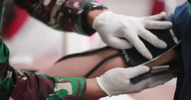 Γιατρός Βάζει Στη Συσκευή Αρτηριακής Πίεσης Ενός Άνδρα Ασθενή Που — Αρχείο Βίντεο