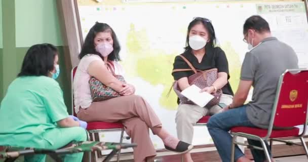 マスクをして診療所のホールで待っている患者 西ジャワ州の診療所でコロナウイルスに感染するのを待つ人々インドネシア — ストック動画